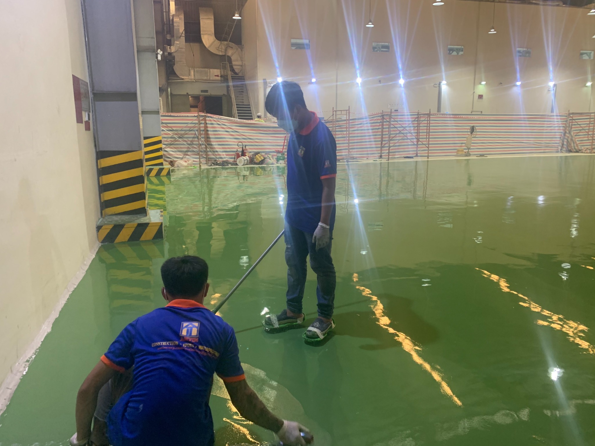 Đội ngũ ANTINCORP thi công lớp phủ epoxy xanh trong nhà xưởng